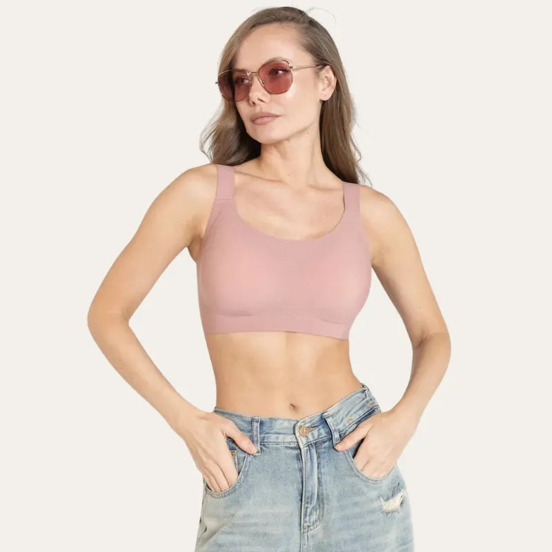 Mulher de óculos vestindo Soutien Aura Rosé sem aro, com as mãos nos bolsos do jeans