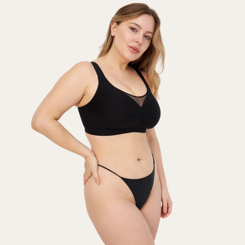 Mulher de lado a usar o Soutien Nabel preto com tanga preta, com recorte em tela no decote