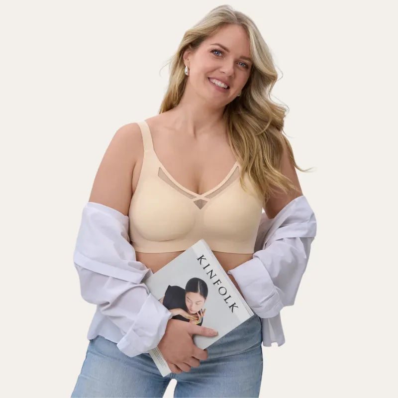 Mulher sorrindo, usando o Soutien Sávia bege sob camisa branca aberta
