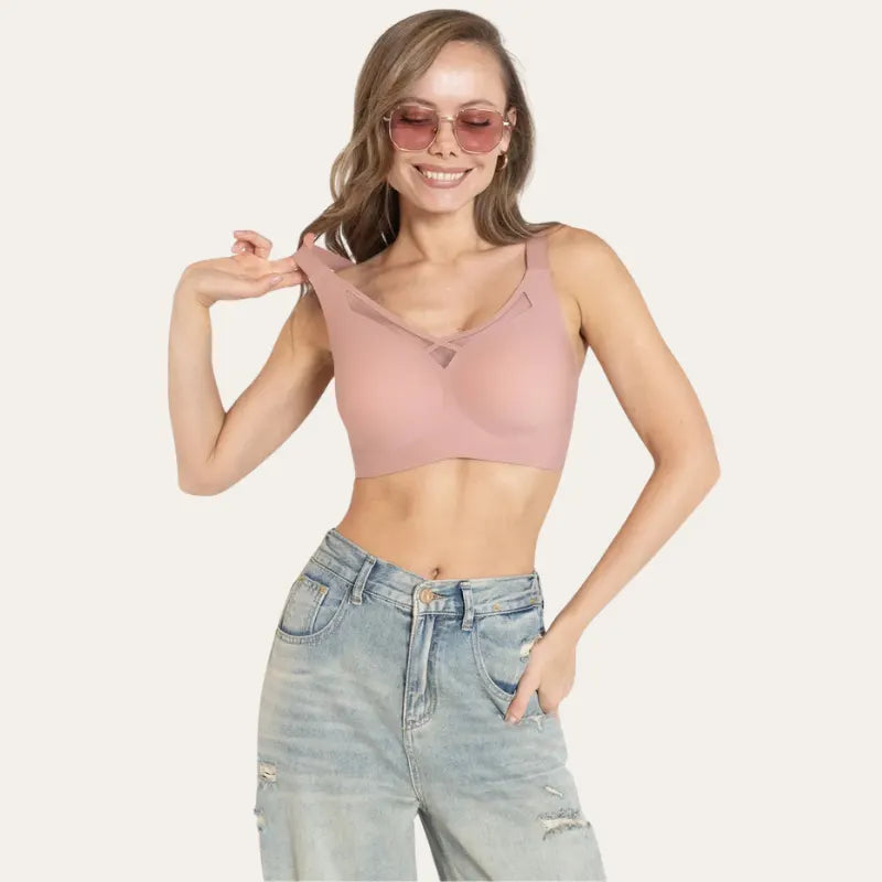 Mulher de óculos vestindo Soutien Sávia Rosé sem aro, com recorte em tela no centro e jeans