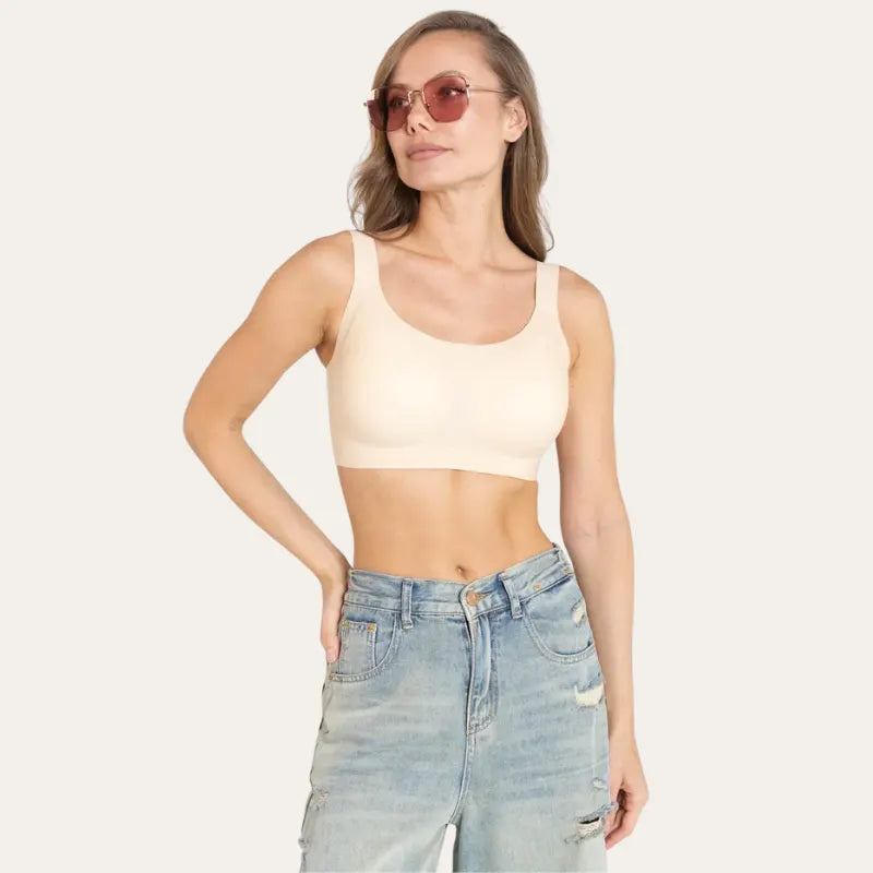 Mulher de óculos vestindo Soutien Aura Bege sem aro, com mão na cintura e jeans