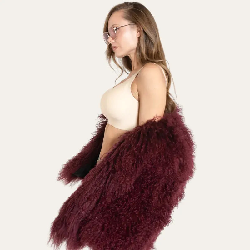 Modelo de perfil com Soutien Aura Bege e casaco de pelúcia bordô