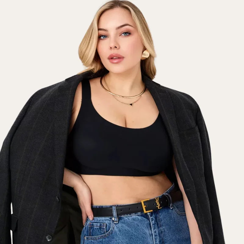 Modelo de frente com Soutien Aura Palum em Preto, copa lisa e cobertura alta, com blazer escuro e cinto