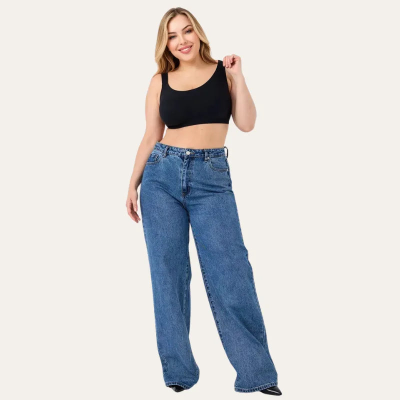 Mulher sorrindo com Soutien Aura Preto e calças de ganga wide leg