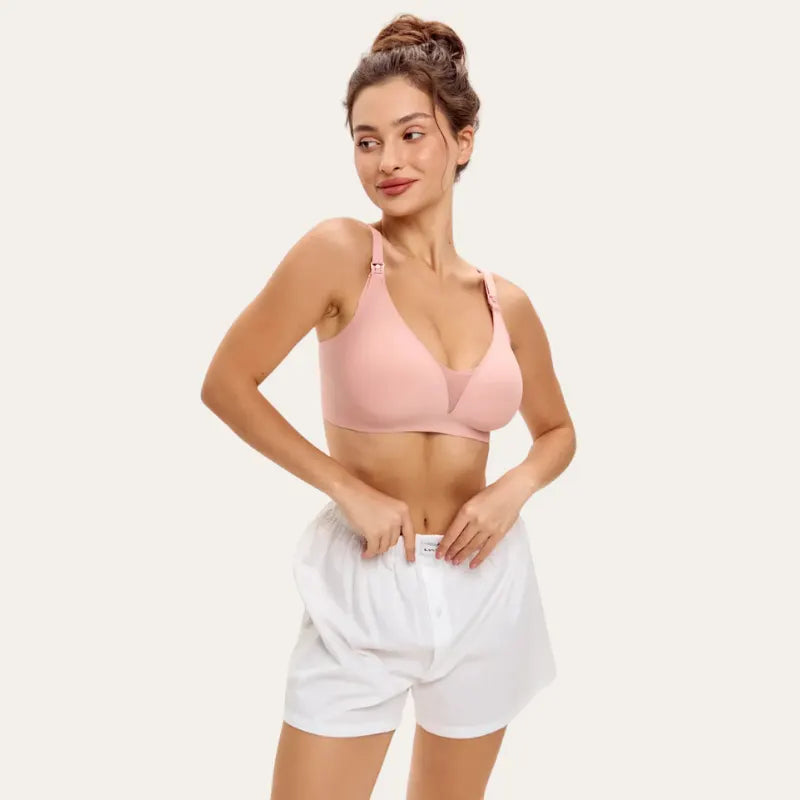 Mulher a usar o soutien para amamentar Serene rosé com calções brancos, com taças moldadas e alças com clip